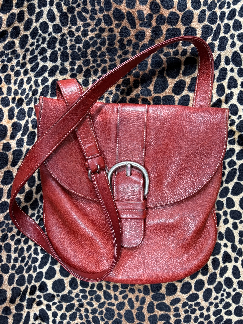 Red Pebbled Leather Crossbody Bag with Interior Pockets and Decorative Buckle